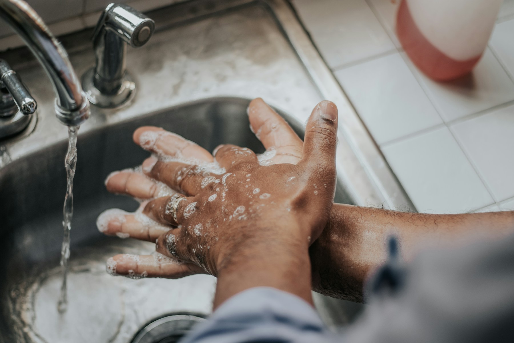 Hands being washed with soap under running water